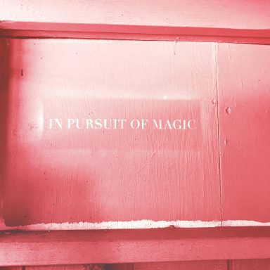 a pink door with in pursuit of magic sprayed on it