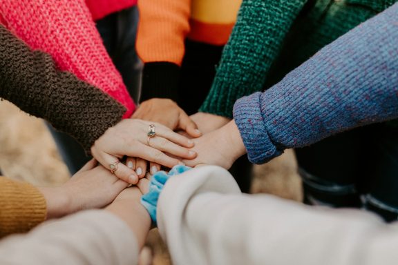 a group of people putting their hands in the middle